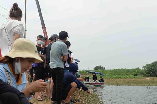 Người dân đứng kín bờ sông theo dõi tìm cô gái Hà Nội mất tích