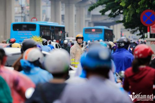 Cảnh sát bất lực nhìn dòng người ùn ùn chen lấn trong mưa giờ đi làm