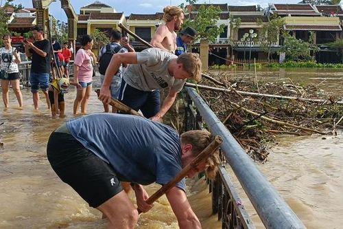 Du khách nước ngoài dọn rác sau bão ở Hội An