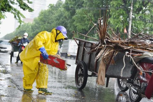 Công nhân vệ sinh môi trường dầm mưa quét dọn rác, khơi thông cống