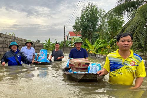 Lội nước đẩy thuyền tiếp tế các hộ dân bị cô lập trong lũ ở Quỳnh Lưu