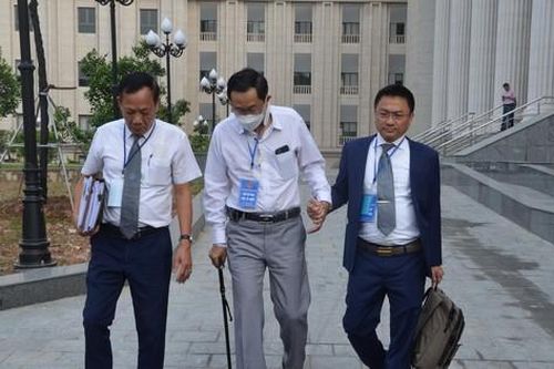 Cựu Thứ trưởng Bộ Y tế Cao Minh Quang chống gậy đi tập tễnh đến tòa