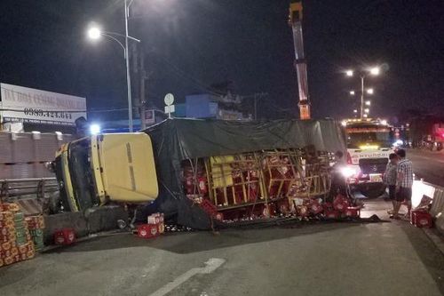 Xe tải lật trên quốc lộ 1, hàng trăm thùng bia đổ ra đường