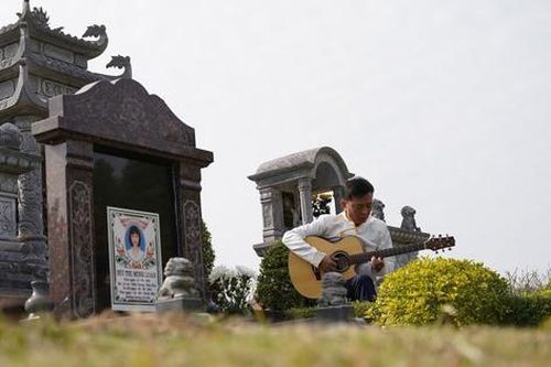 Người đàn ông ngồi hát bên mộ vợ trong lễ tạ mộ ngày cuối năm