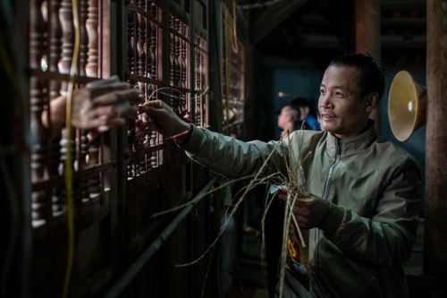Thò tay qua khe cửa giành manh chiếu trong hội Đúc Bụt ở Vĩnh Phúc