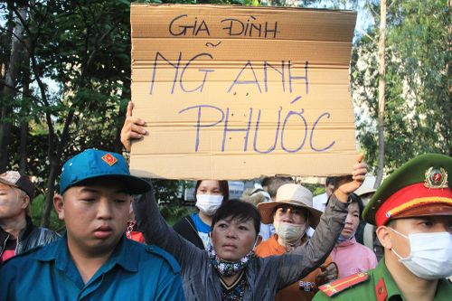 Người mẹ giơ cao tấm biển ghi tên con trai trong lễ giao nhận quân ở TP.HCM
