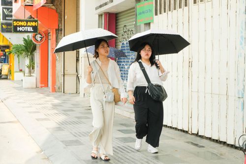 Khách nước ngoài tìm mọi cách để tránh nắng ở TP.HCM
