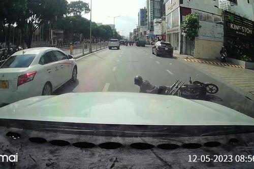 Vượt khe hẹp giữa hai ô tô trên phố, nam thanh niên đi xe máy bị ngã đau
