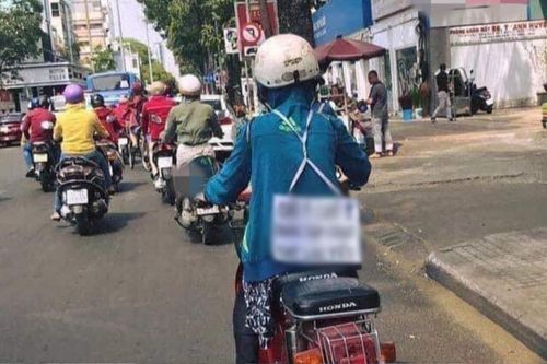Người phụ nữ đeo tấm bảng sau lưng khi chạy xe máy, vừa nhìn ai nấy cũng chủ động giữ khoảng cách