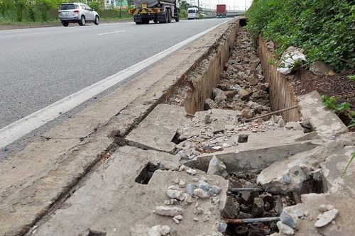 Cảnh hàng trăm tấm đan cống thoát nước dọc xa lộ Hà Nội bị đập vụn