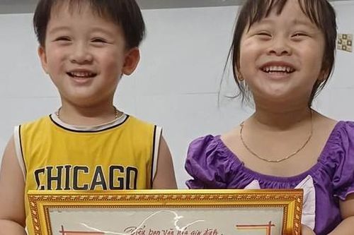 Hai bé song sinh hạnh phúc được ông ngoại tặng tấm giấy khen 'vô giá'
