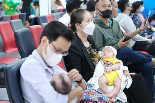 Người dân tranh thủ vừa tiêm chủng, vừa tránh nóng