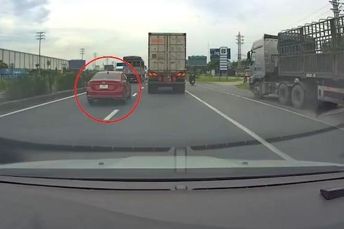 Chuyển làn ẩu, xe tải húc ô tô con văng lên dải phân cách
