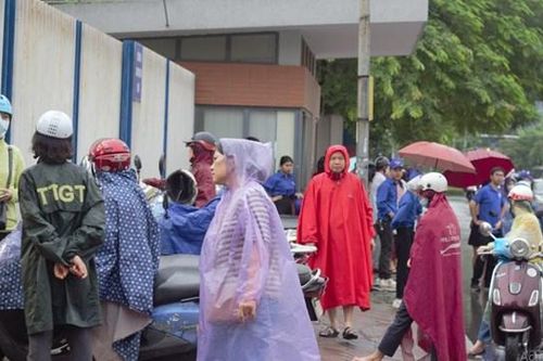 Phụ huynh 'đội mưa' chờ con thi tốt nghiệp THPT 2023