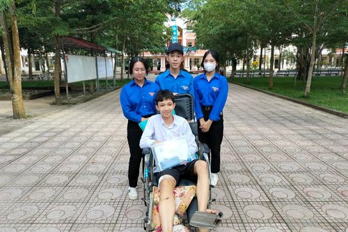 Tình nguyện viên hỗ trợ đưa thí sinh gãy chân vào phòng thi