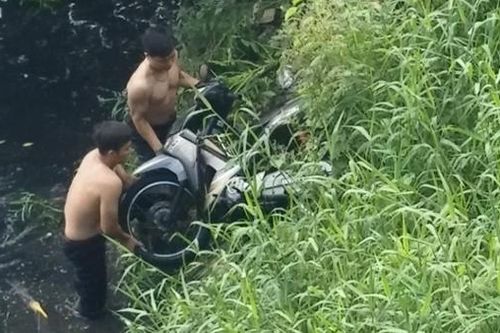 Phát hiện chiếc xe tay ga nằm bất thường dưới kênh nước đen