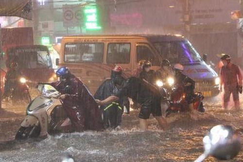 TPHCM: Nước ngập sâu, chảy mạnh sau mưa lớn, người dân vất vả đẩy xe máy