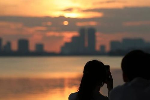 Du khách nước ngoài mê mẩn ngắm hoàng hôn ở Hồ Tây