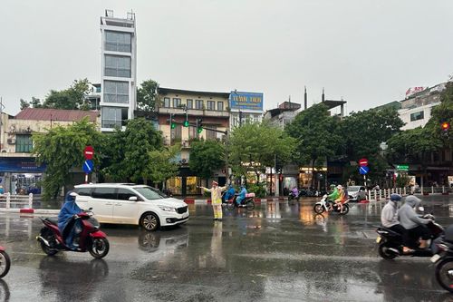 Cảnh sát giao thông Thủ đô dầm mưa phân luồng, đảm bảo cho người dân đi lại an toàn