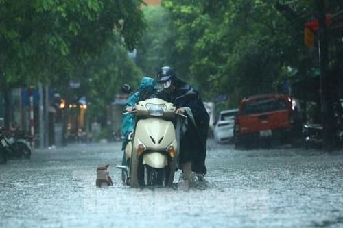 Mưa tầm tã, người dân Hà Nội chật vật 'bơi qua biển nước'