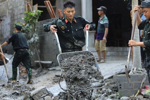 Chiến sĩ Cảnh sát cơ động giúp dân dọn bùn từ vụ vỡ cống tràn xả thải ở Lào Cai