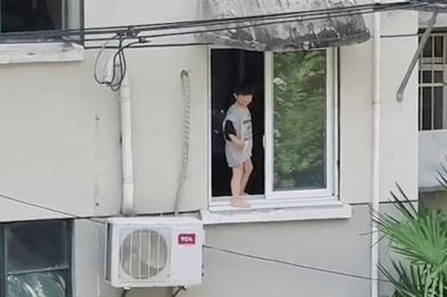 Hãi hùng cảnh cậu bé đứng bấp bênh bên mép cửa sổ chung cư