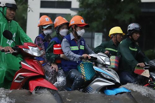 Mưa lớn ở TP.HCM, người dân đánh vật với làn nước ngập