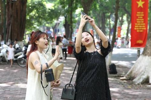 Chị em tấp nập 'săn' nắng thu trên con đường lãng mạn nhất Thủ đô