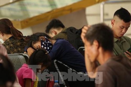 Nhiều người mệt mỏi ngủ vùi ở bến chờ đón xe về quê nghỉ lễ