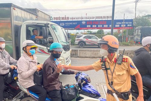 CSGT TP.HCM phát nước suối, tặng nón bảo hiểm cho người dân về quê