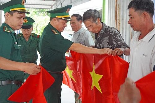 Tặng cờ Tổ quốc và móc khóa khắc số điện thoại đường dây nóng cho bà con Quảng Trị