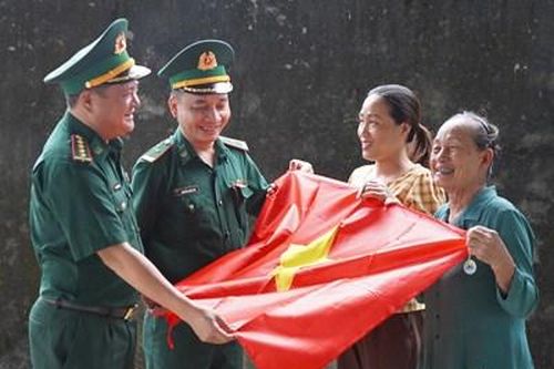 Trao tặng cờ Tổ quốc và móc khóa in số điện thoại đường dây nóng khu vực biên giới Quảng Trị