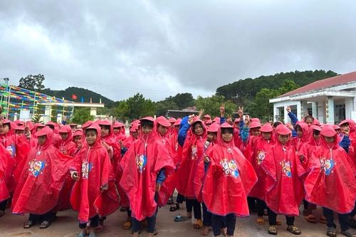 Cán bộ, giáo viên tặng áo mưa cho học sinh Xơ Đăng