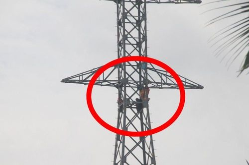 Hai người ngồi vắt vẻo trên trụ điện cao thế