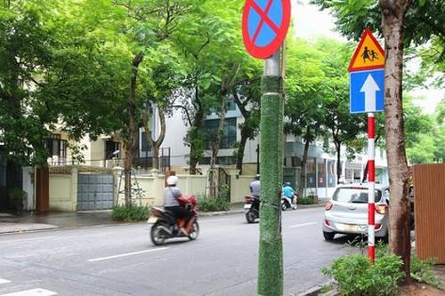 Ốp nhựa quanh cột đèn để hạn chế quảng cáo, rao vặt trên đường phố Hà Nội
