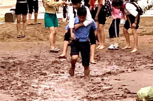 Xúc động hình ảnh hiệu trưởng cõng học sinh lội bùn đến trường