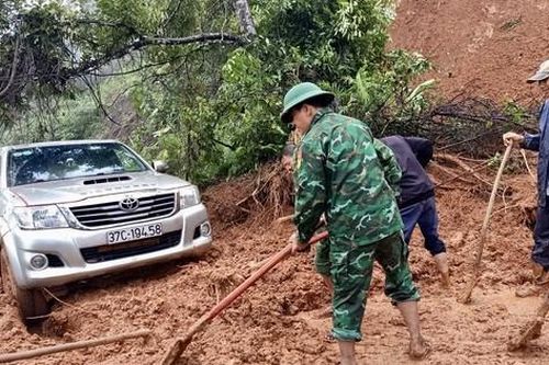Lính quân hàm xanh cào bùn thông tỉnh lộ cho xe qua