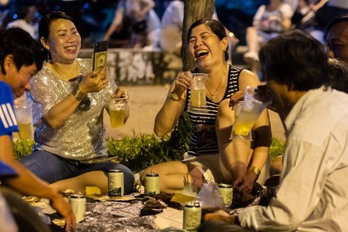 Trải bạt ngồi ăn uống trên bờ biển Cần Giờ chờ xem thả hoa đăng