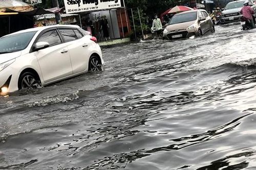 Người dân TP HCM bì bõm di chuyển trong mưa lớn và triều cường
