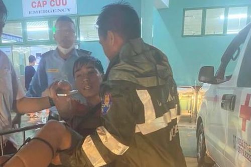 Lực lượng cứu hộ ngâm mình trong nước đưa sản phụ ra khỏi vùng ngập lụt