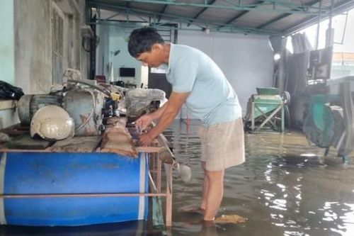 Người dân vùng ngập tự chế bè nổi bằng thùng nhựa chứa cả tấn đồ trên nước lũ