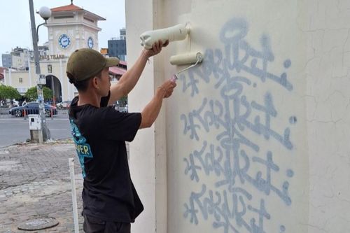 Thanh niên bị buộc sơn lại tường trước chợ Bến Thành sau khi vẽ bậy