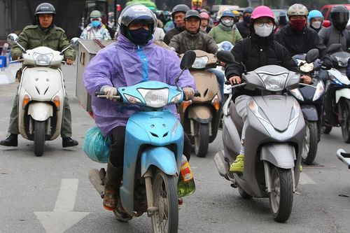 Người Hà Nội trùm áo mưa chống chọi với đợt giá lạnh nhất từ đầu mùa đông