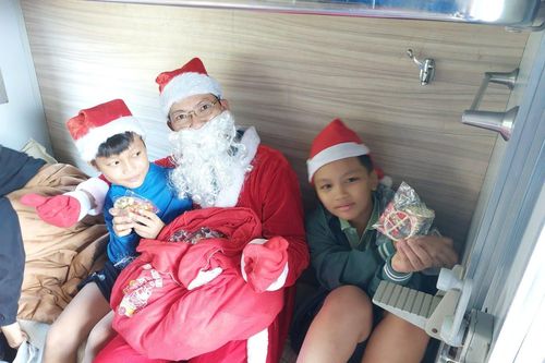 Hành khách đi tàu thích thú vì được ông già Noel phát quà