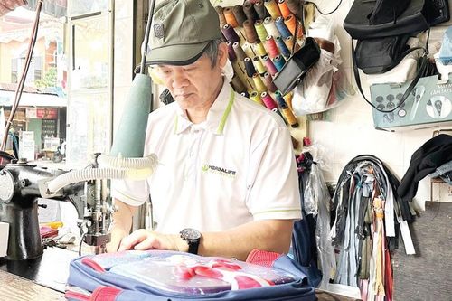 Bác Hòa sửa ba lô cũ...