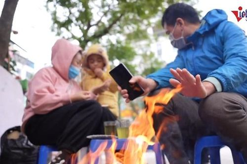 Hà Nội rét 'thấu da thịt', người lái xe máy ra đường cóng tay phải dừng sưởi ấm