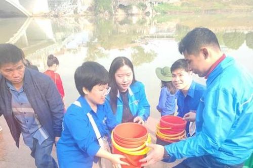 Đoàn viên thanh niên hỗ trợ người dân thả cá cúng ông Công, ông Táo