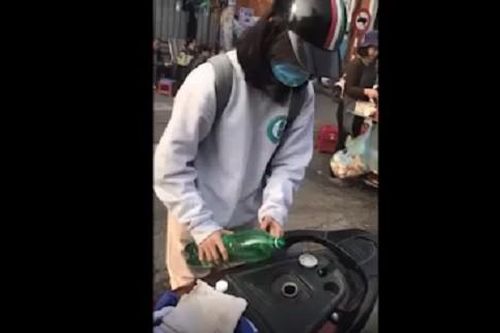 Cô gái loay hoay không đổ được xăng từ chai vào xe máy