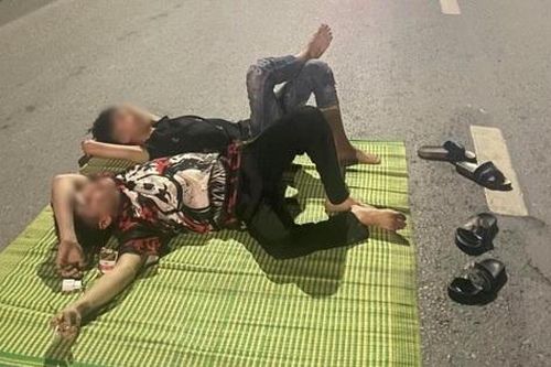 Hai nhân viên quán ốc nằm trên quốc lộ chụp ảnh 'câu like'
