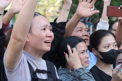 Mẹ đứng trước cổng dõi xem con mặc áo lính trong ngày nhập ngũ